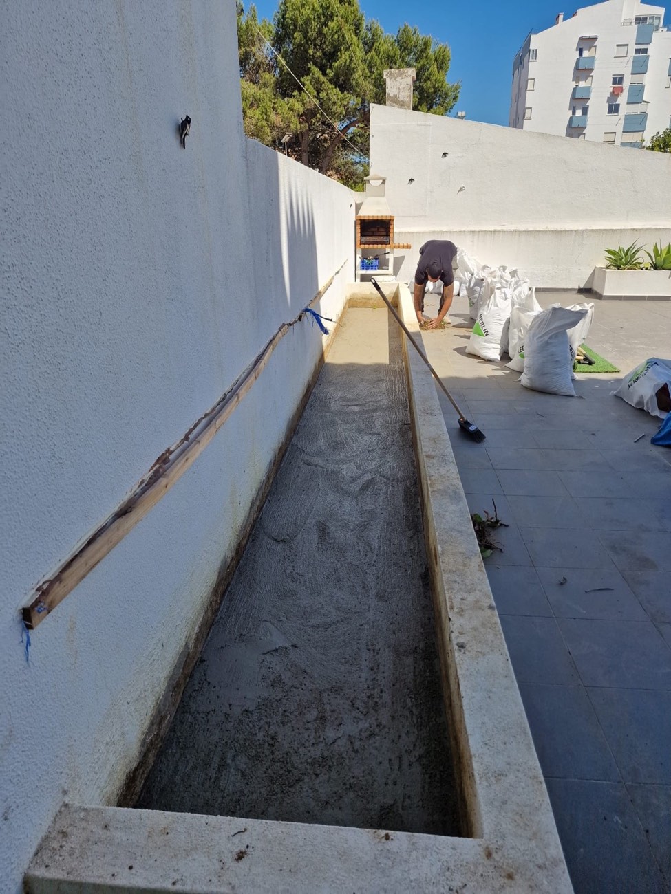 Floreira de betão vazia no terraço, antes da impermeabilização